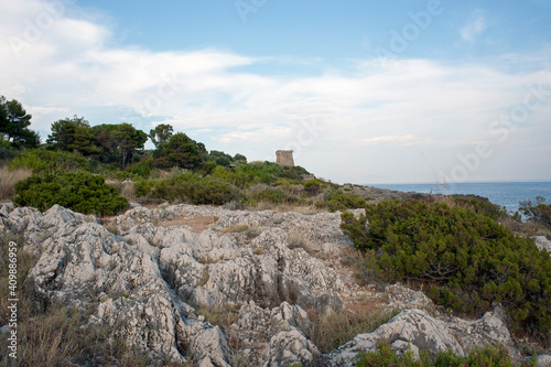 Striking view of a rough bluff against the skyline with one of the ancient Bourbons turrets overlooking the inlet above the beautiful Calanca cove. Salerno, Marina di Camerota, Italy. photo