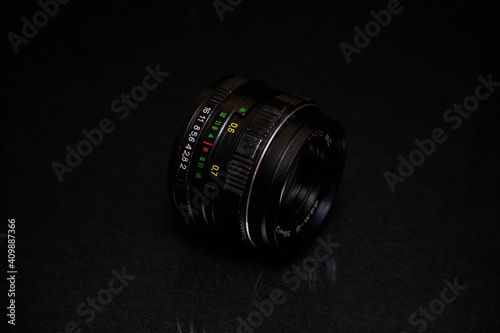 Lens from the USSR on a black background and glass