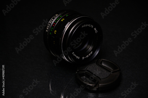 Lens from the USSR on a black background and glass