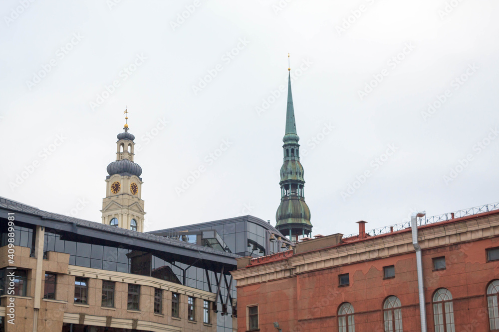 Obraz premium Famous view on latvian highest unique medieval and gothic architecture churches towers and the roofs of old houses on street in the center of capital old city Riga, Latvia, the Baltics region 