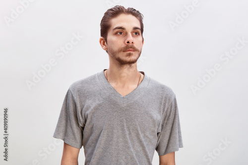 People concept - bearded face man. Friendly young man in gray shirt look in to the camera over grey background. Copy space © oleg_ermak