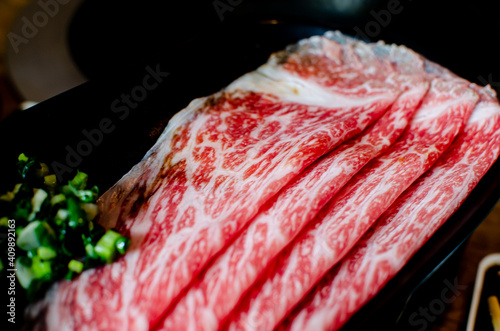 Grilled wagyu beef with beautiful fat on tradition charcoal grill stove. Japanese Barbecue mixed with seafood bbq. All marbled meat cooking on original asian heat plate. 