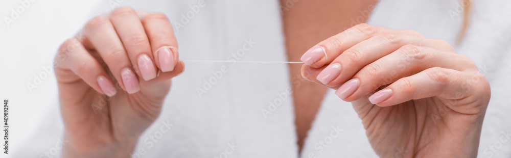cropped view of woman holding dental floss in hands, banner cropped view of woman holding dental floss in hands, banner