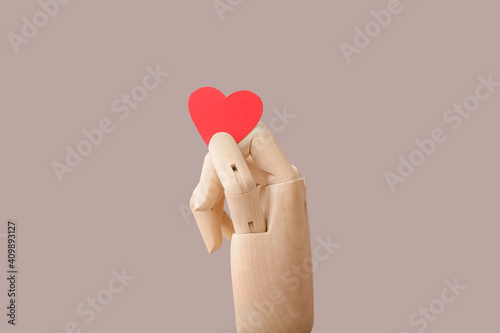 Wooden hand with red heart ...