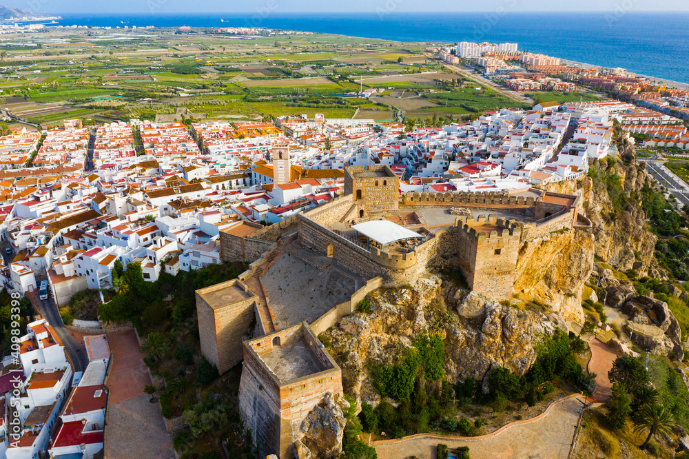 Scenic aerial view of Salobrena cityscape and Moorish castle on background with blue water surface of Mediterranean Sea, Spain