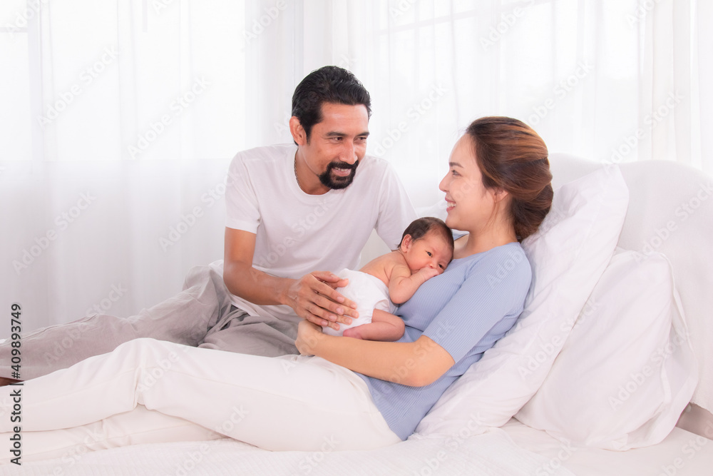 Beautiful women married man with beard Hispanic mix race, husband hold and looking wife and baby infant with love, mother embrace newborn son softly caring and protection on bed, happy family concept