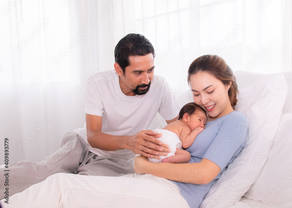 Beautiful women married man with beard Hispanic mix race, husband hold and looking wife and baby infant with love, mother embrace newborn son softly caring and protection on bed, happy family concept Beautiful women married man with beard Hispanic mix race, husband hold and looking wife and baby infant with love, mother embrace newborn son softly caring and protection on bed, happy family concept
