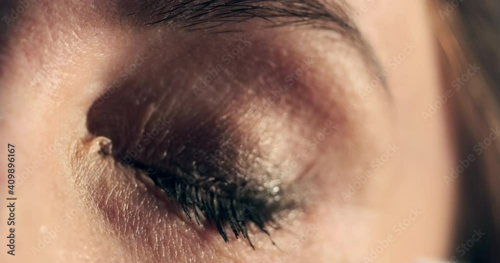 Woman cleans her eye. Young woman cleans her eye from make up, extreme close up shot of the mascara cleaning process Woman cleans her eye. Young woman cleans her eye from make up, extreme close up shot of the mascara cleaning process