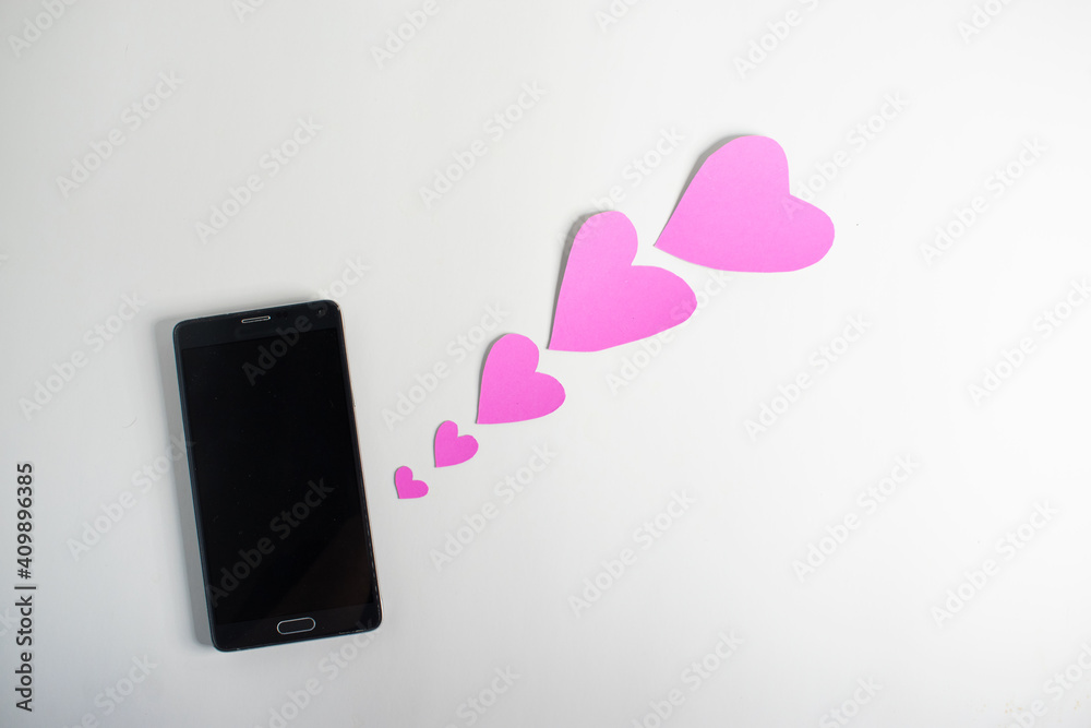 Smartphone and hearts paper on
White background. Valentine or Sending love through social networks. Smartphone and hearts paper on
White background. Valentine or Sending love through social networks.