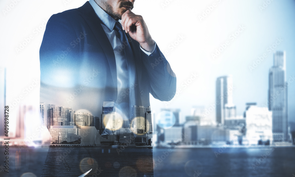 Fototapeta premium Businessman looking into the distance on rooftop with city view.