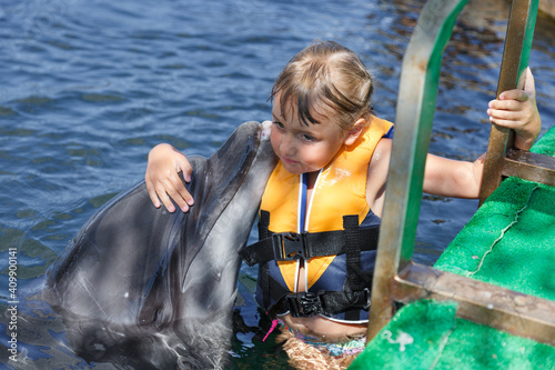 little girl and dolphin in the pool