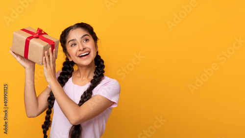 Young Indian Woman Shaking Present At Orange Studio
