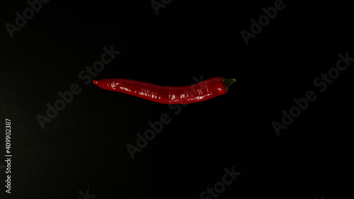 Fresh red chili pepper on black background.