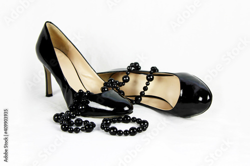 Zapatos de charol negro y tacón alto con un collar de perlas negras  photo