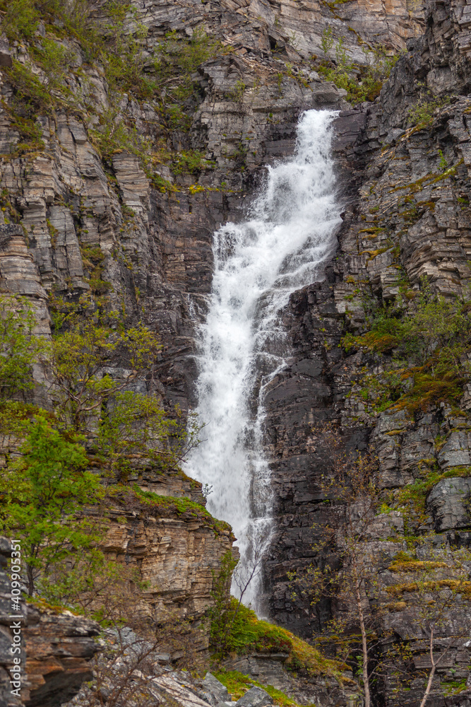 Towering waterfall falling from the rock, Finnmark, northern Norway.