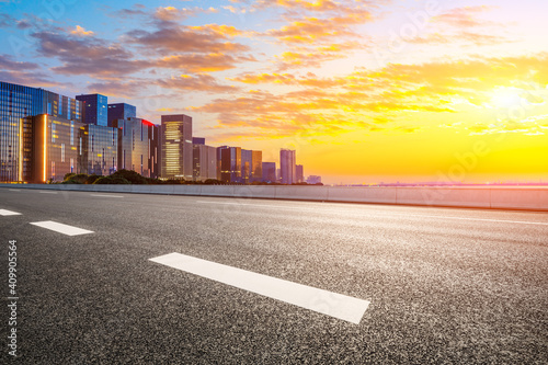 Empty asphalt road and modern city skyline in Hangzhou at sunrise,China.