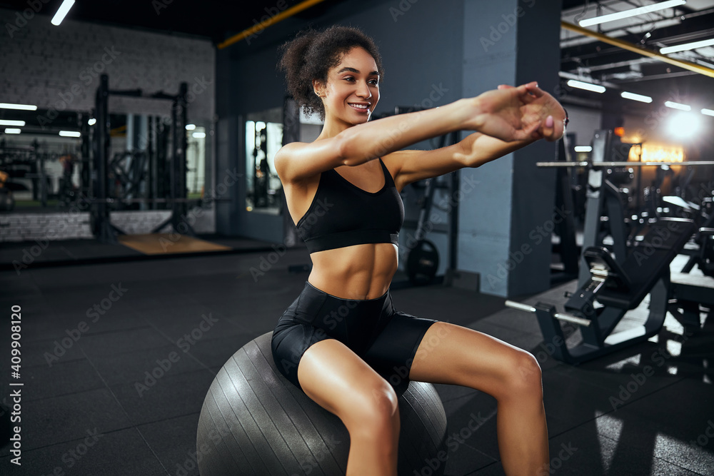 Positive delighted female person sitting on fitness ball Positive delighted female person sitting on fitness ball