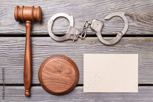 Flat lay justuce and court concept. Blank paper for copy space. Wooden gavel with handcuffs on the desk. photo