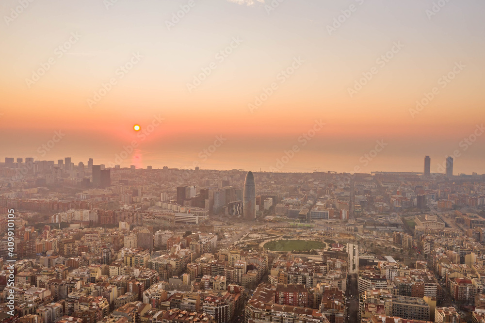 Aerial drone shot of rising sun over Barcelona city beach