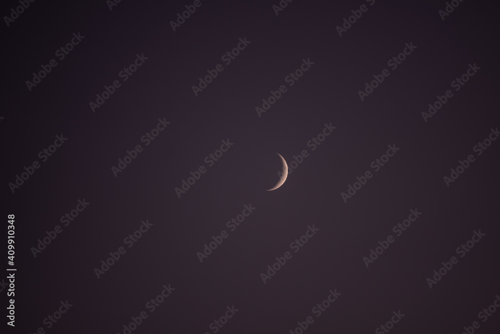 young crescent moon on a clear sky at the end of the day in the summer young crescent moon on a clear sky at the end of the day in the summer