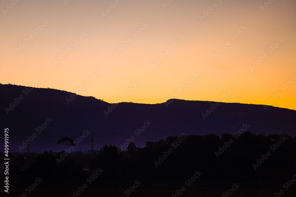 Golden morning sky in winter, misty high mountain background. Silhouette hills and misty in the morning at Chaiyaphum,Thailand.