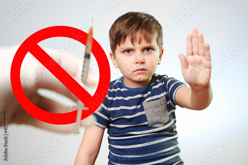 no vaccination.  little boy stops hand vaccination against covid-19.  syringe crossed out with a red sign