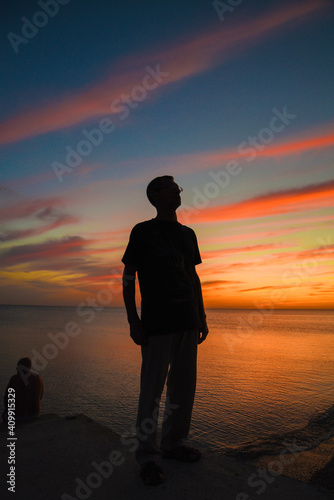 Silhouette of a man against the backdrop of a sunset seascape
