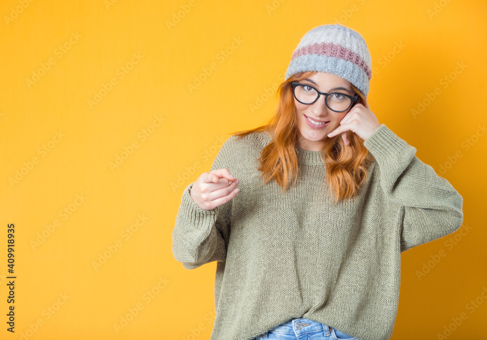 Call me. Woman gesturing at speaking on phone while looking to camera, isolated on yellow background. Woman on phone Call me. Woman gesturing at speaking on phone while looking to camera, isolated on yellow background. Woman on phone