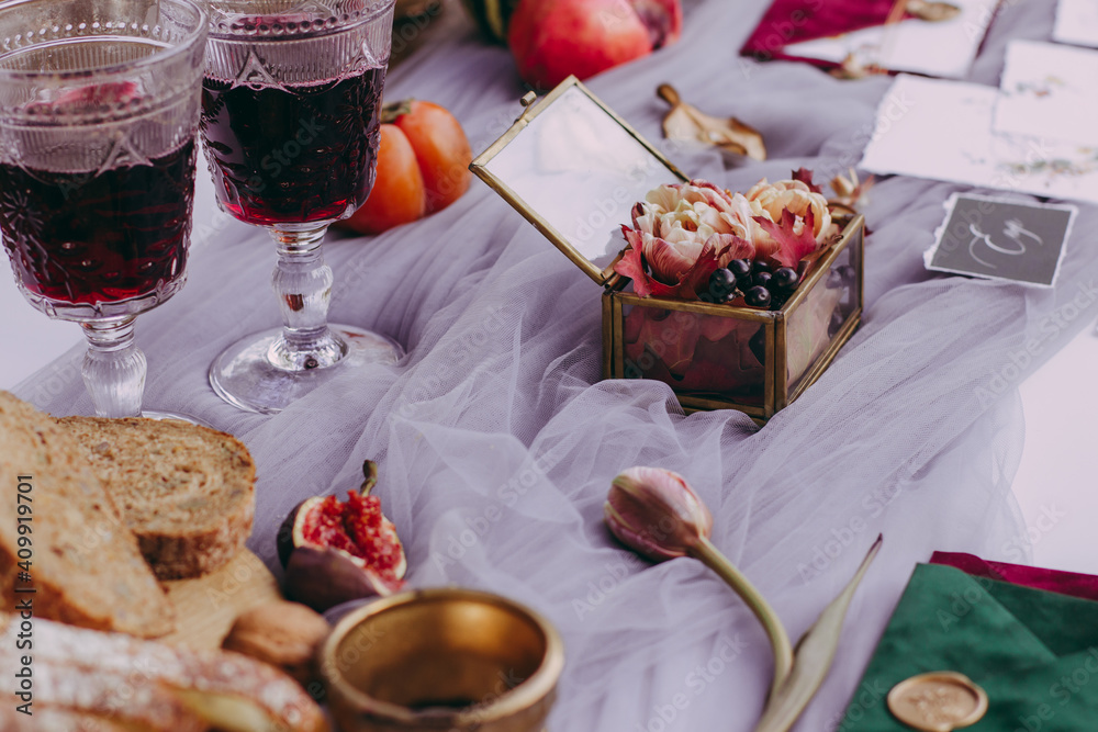 Cute wedding details on the table, glass wedding ring box with glasses of red wine