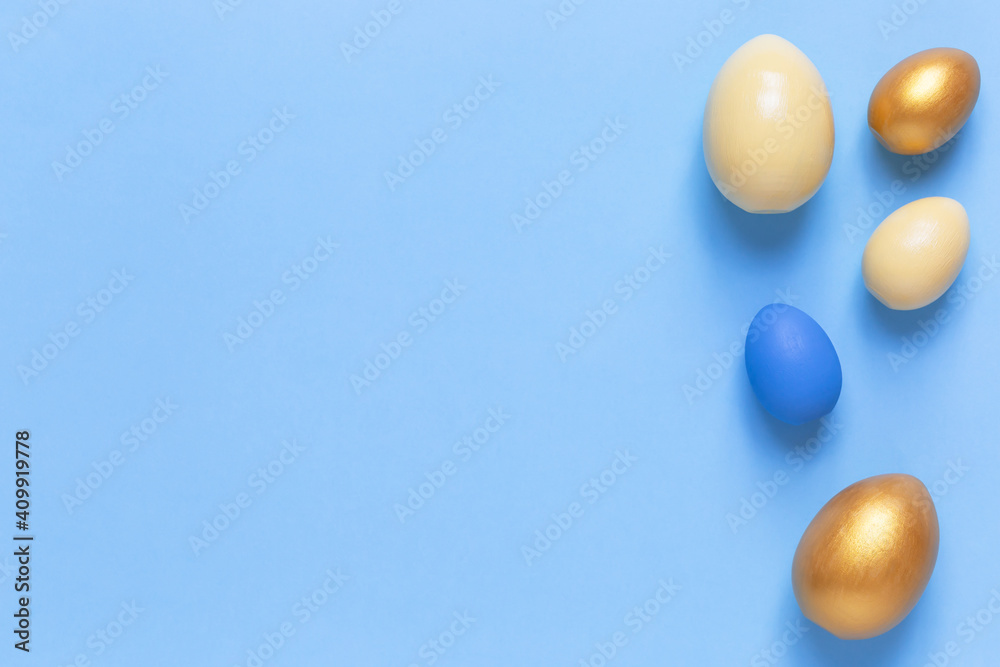 Colorful Easter eggs on a blue background. Flat lay, a copy of space. Easter decoration, modern design pattern
