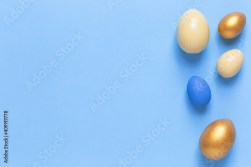 Colorful Easter eggs on a blue background. Flat lay  a copy of space. Easter decoration  modern design pattern