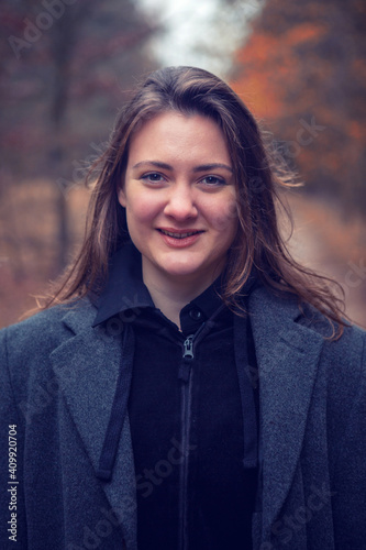 young brunette smiling woman in the forest in autumn