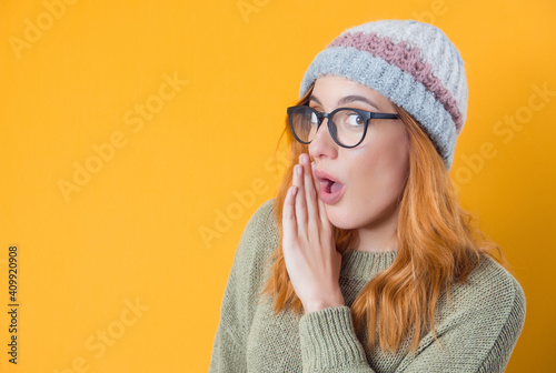 Woman holding hand near mouth and telling secret, isolated on yellow background. Gossip concept