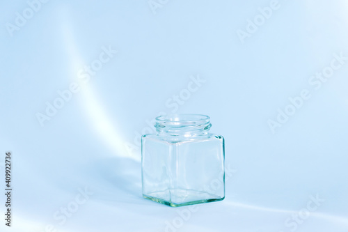 Empty glass bottle on the blue background with light effect