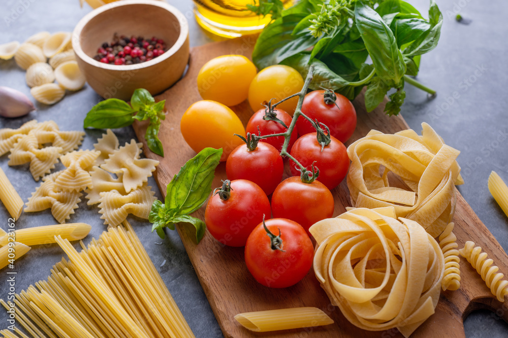 Mixed dried pasta selection on wooden background. composition of healthy food ingredients isolated on black stone background, top view, Flat lay. Mixed dried pasta selection on wooden background. composition of healthy food ingredients isolated on black stone background, top view, Flat lay.