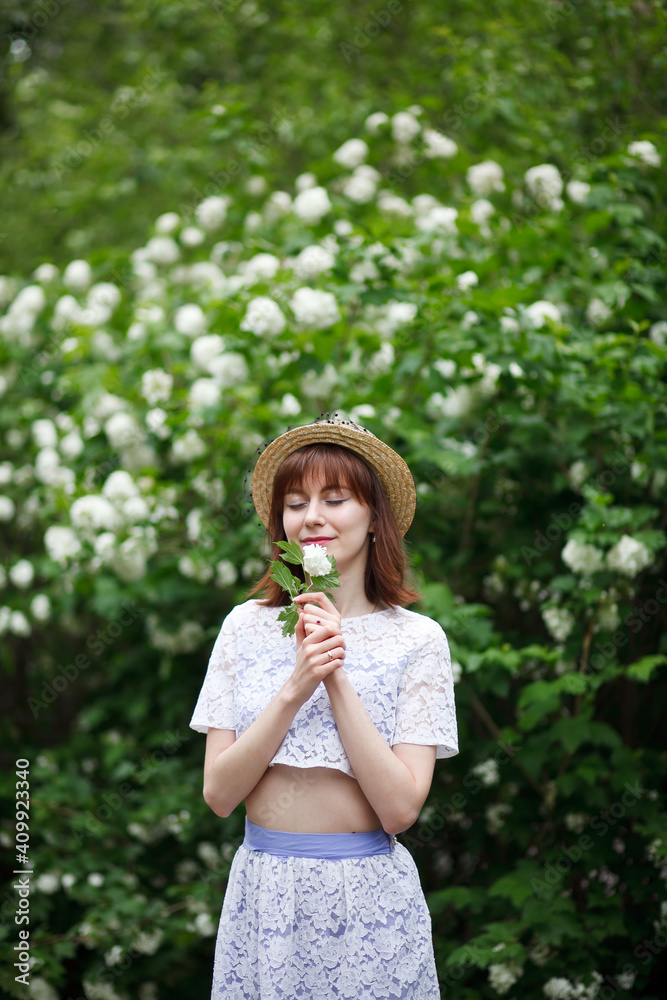 a girl in a straw hat walks in a blooming garden a girl in a straw hat walks in a blooming garden