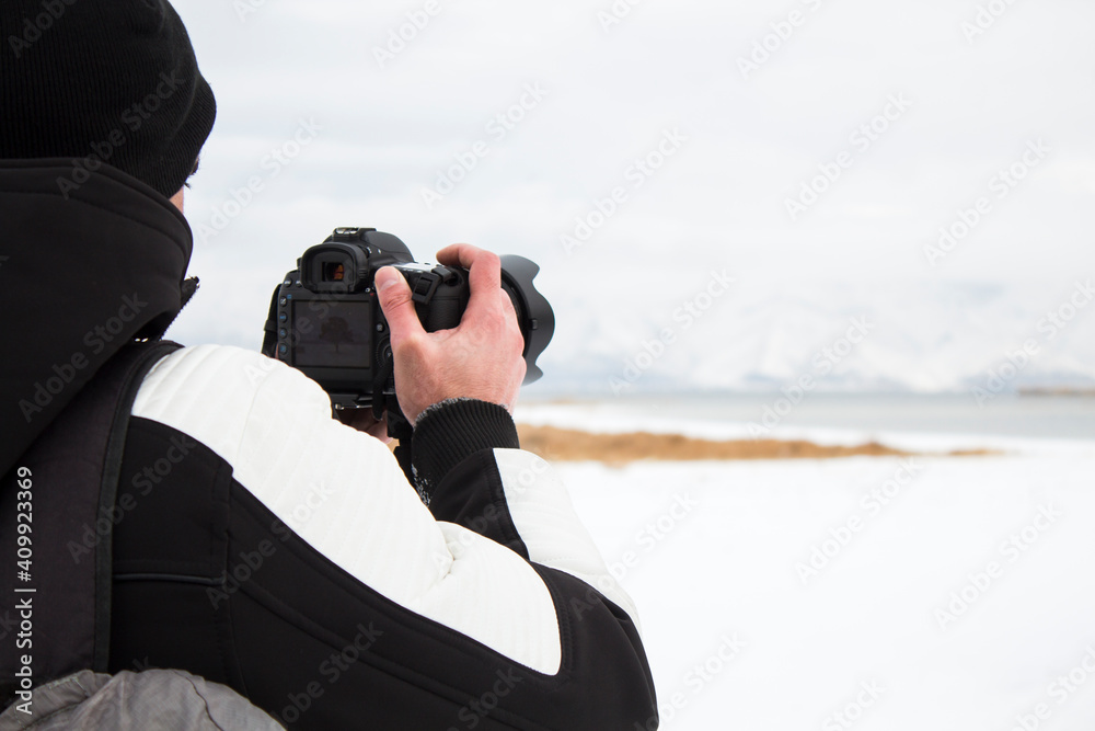 Obraz premium photographer taking pictures of the lake in winter