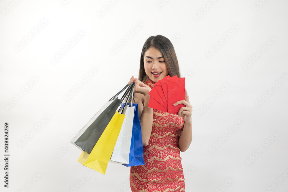 Asian woman holding shopping bags and red envelopes isolated on white background for Chinese New Year sale concept Asian woman holding shopping bags and red envelopes isolated on white background for Chinese New Year sale concept