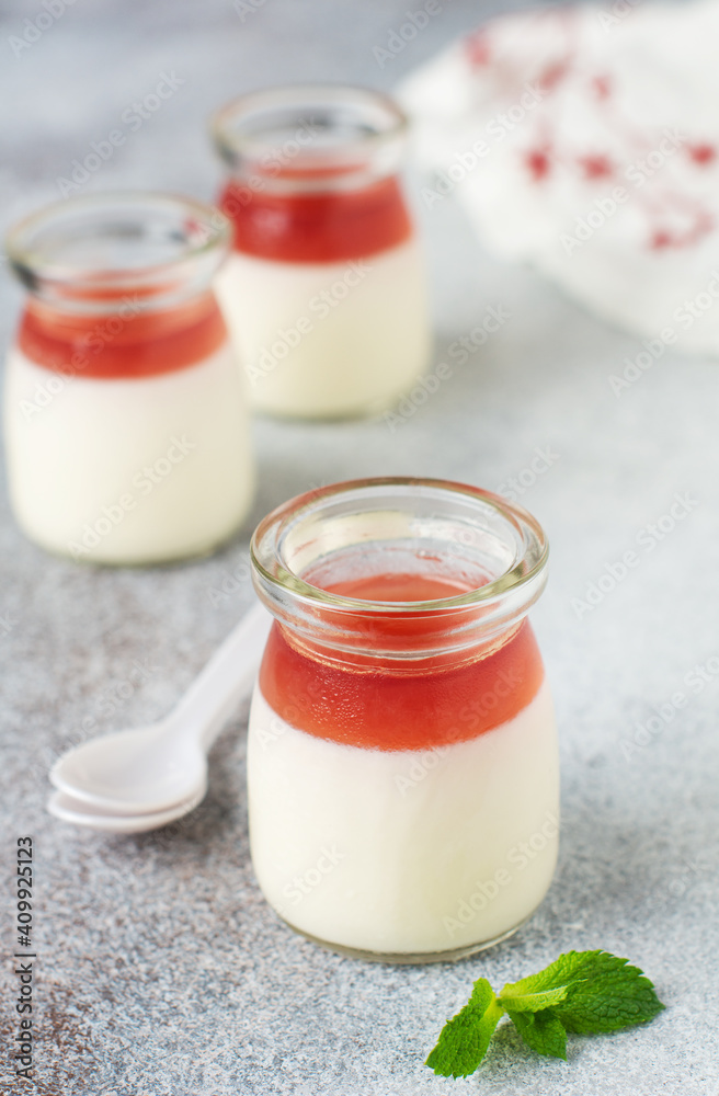 Festive dessert with berry jelly, vanilla panna cota and fresh strawberry on gray concrete table background. Selective focus. Festive dessert with berry jelly, vanilla panna cota and fresh strawberry on gray concrete table background. Selective focus.