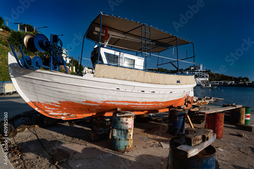 Traditional wooden fishing boat during painting at the harbor of Linaria in Skyros island, Greece © dinosmichail