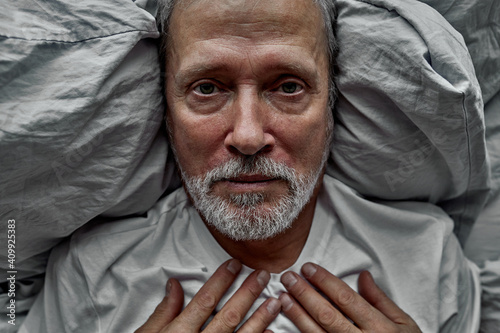 depressive man lie on bed alone looking at camera, suffering from loneliness, no meaning in life