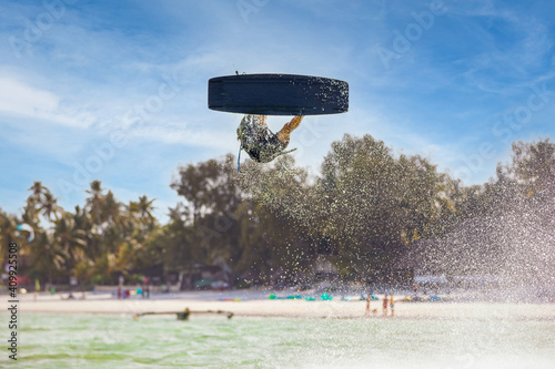 Kite surfing - Kite surfer jumping high in the air while performing a trick