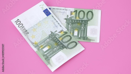 100 euro bills on pink background. close-up