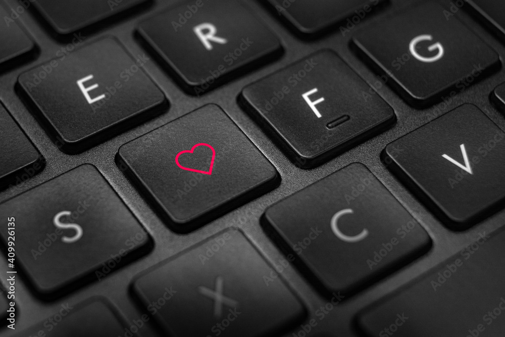 Close up of black and white keyboard with red heart olutline on one of the buttons Close up of black and white keyboard with red heart olutline on one of the buttons