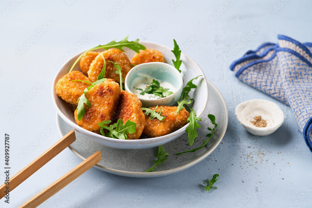 Vegetarian Nuggets with Vegan Dipping Sauce and rocket leaves on a light background with copy space, selective focus. Healthy Diet, Protein Vegetarian Meals concept, alternative meat products. Vegetarian Nuggets with Vegan Dipping Sauce and rocket leaves on a light background with copy space, selective focus. Healthy Diet, Protein Vegetarian Meals concept, alternative meat products.