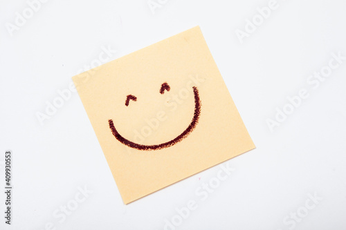 Happy smiley face drawn on yellow post-it notes
