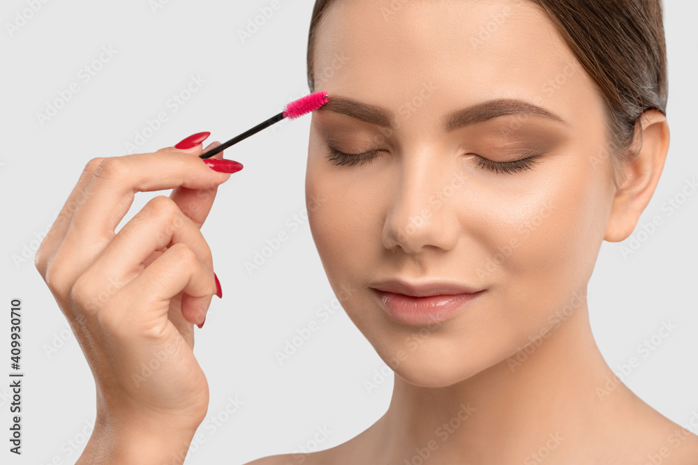 Makeup artist combs  and plucks eyebrows after dyeing in a beauty salon.Professional makeup and cosmetology skin care.