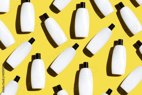 Pattern of the cosmetic bottles on the illuminating yellow background. Cosmetics flat lay. copy space. Trendy color of the year 2021