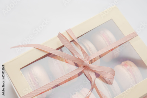 Box with delicate French macaroons on a white background. Gift. Valentine's Day. Advertising. Postcard. Dessert. Confectioner. France. Biscuit. Love.