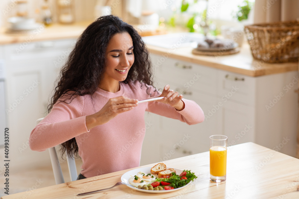 Food Blogger. Young smiling woman taking photo of her brekfast with smartphone Food Blogger. Young smiling woman taking photo of her brekfast with smartphone